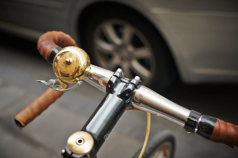 Detailed view of a bicycle bell mounted on handlebars, illustrating urban biking.