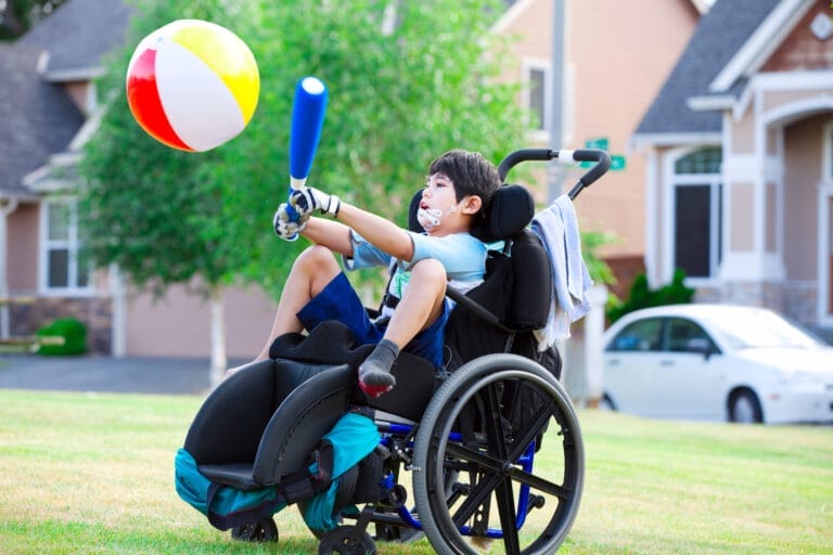 Boy with Cerebral palsy trying to hit the ball with a bat