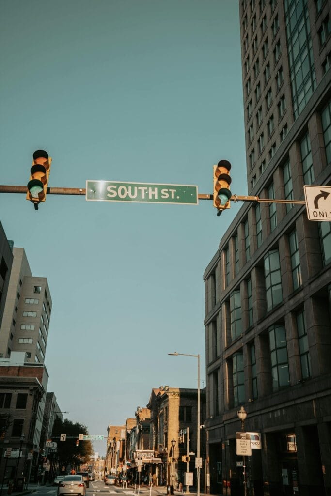 Street view with traffic lights and South St. sign in Baltimore at sunset.